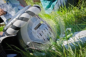 Medieval knight iron helmet lies in the grass
