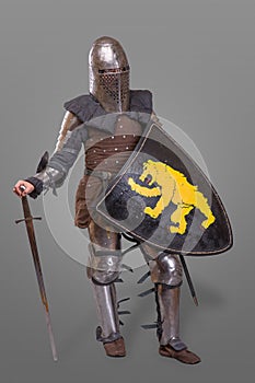 Medieval knight with Sword, Shield, Helmet against grey background