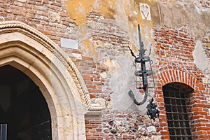 Medieval luminaire on old brick wall of a house