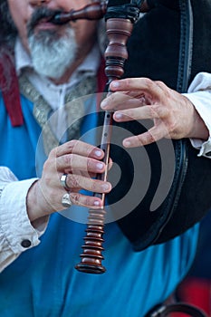 Medieval minstrel playing bagpipe photo