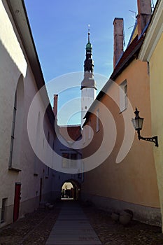 Medieval Narrow Street in Tallinn with a lantern on the wall and a church in front, Estonia