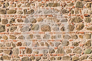 Medieval old wall made of stones and bricks