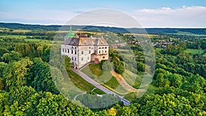 Medieval Olesko Palace aerial view. Green spring trees. Summer park on hills