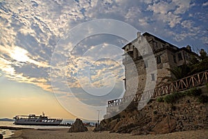 Medieval Ouranoupoli Tower with pilgrims ferry boat, Chalkidiki, Greece