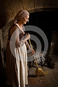 Medieval peasant woman working at fireplace