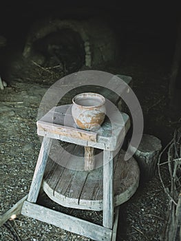 Medieval potter`s wheel with an old pottery kiln in the background