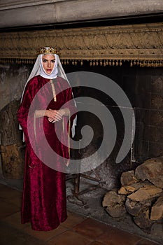 Medieval queen in front of fireplace