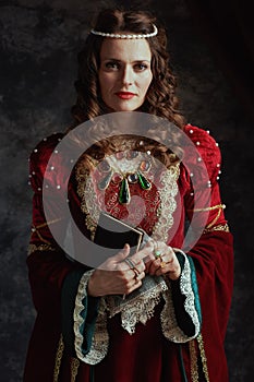 medieval queen in red dress with book and handkerchief