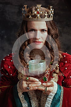 medieval queen in red dress with goblet and crown