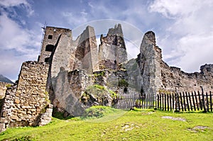 Medieval ruins panorama or castle with beautiful blue sky and green meadow. View of Likava castle in Likavka village in Slovakia.
