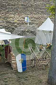 Medieval scene against the historical backdrop of an old city wall, village with tents of various designs, view of tents, village