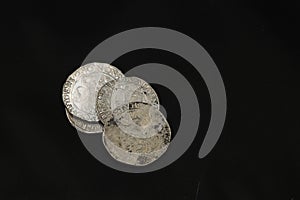 Medieval silver coins one taller on black background