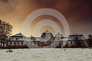 Medieval snowy castle in winter at night with beautiful orange - red sky. Creepy castle in Slovakia. European historic large castl