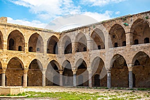 Medieval square building with a courtyard and many arches