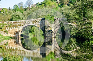 Medieval stone bridge over the Arnoia river in the beautiful village of Allariz, Galicia photo