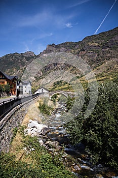 Medieval stone bridge over the river in Espot village in Pyrenees mountains photo