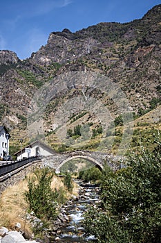 Medieval stone bridge over the river in Espot village in Pyrenees mountains photo