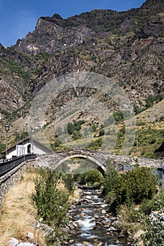 Medieval stone bridge over the river in Espot village in Pyrenees mountains photo