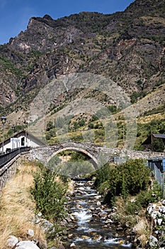 Medieval stone bridge over the river in Espot village in Pyrenees mountains photo