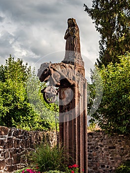 Medieval stone statue over an old well, Alsace, territory of Andlau Abbey