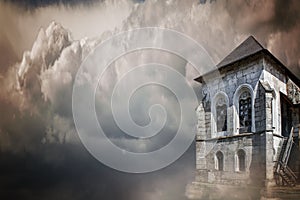 medieval stone tower on clouds sky background