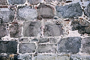 Medieval stone wall made of old and large rectangular massive stone blocks as surface texture background