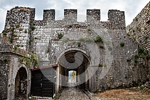 Medieval stone wall with tunnel and gate of Rozafa castle in Shkodra Albania. Ancient antique landscape with a dilapidated