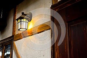 Medieval street lamp on the white wall inside the feudal castle photo