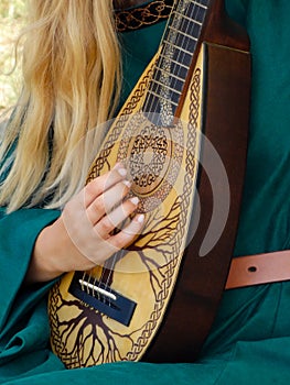 Medieval strings instrument played by a girl with delicate hands