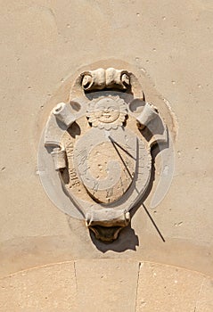 A medieval sundial on an old house facade