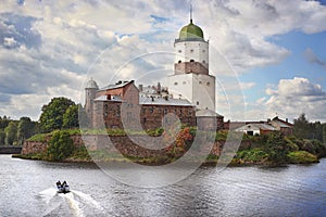 Medieval swedish castle with St Olaf tower in Vyborg and cutter at foreground photo