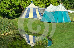 Medieval tents reflected in pond. Tudor reenactment.