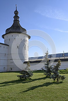 Medieval tower, fortress wall and dancing fir trees in the courtyard of the monastery in Rostov the Great