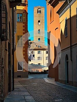 Medieval tower among old historic buildings in Alba, Italy