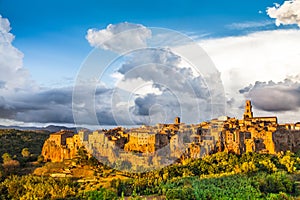 Medieval town of Pitigliano with dramatic clouds at sunset, Tuscany, Italy