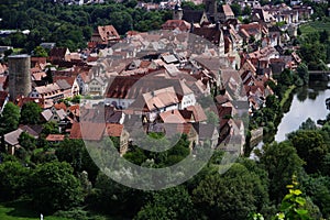 Medieval town surrounded by forest next to a river