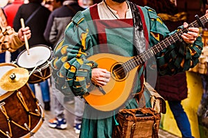 Medieval troubadour playing an antique guitar