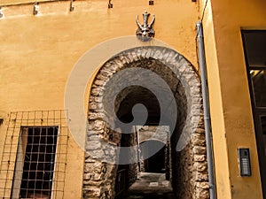 Medieval tunnel-street in the old town of Cervera Lleida, Catalonia. Arched passage with an ancient devil or goat sign on the