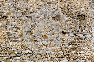 Medieval wall with holes on wooden beams that fell out of time