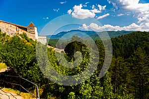 Medieval walled city Rasnov on hill, Romania. Autumn landscape with Medieval fortification Castle Rasnov