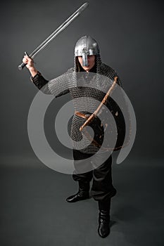 Medieval warrior of the late Viking era and the beginning of the Crusades. Knight in chain mail and helmet photo