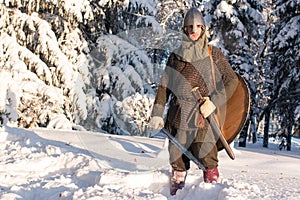 Medieval warriorin in armor in the winter forest