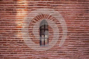 Medieval window in red brick wall