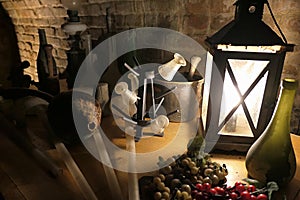 Medieval wine production equipment, lit by vintage lantern in cellar.