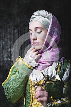 Medieval woman holds a Catholic cross.