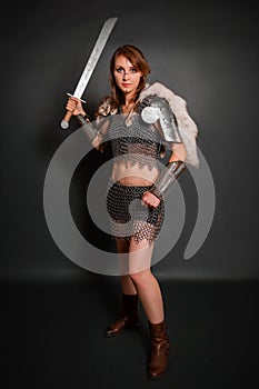 Medieval woman warrior in chain mail armor with lamellar bracers and lamellar shoulder pads with polar fox fur