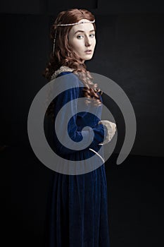 Medieval woman in a blue velvet dress photo