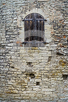 Medieval wooden door in stone castle facade.