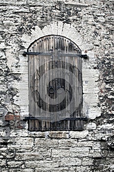 Medieval wooden shutter at a window in an ancient stone wall. Tallinn