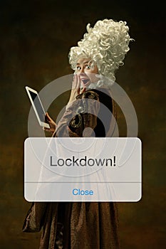 Medieval young woman in old-fashioned costume with tablet behing the message with word Lockdown